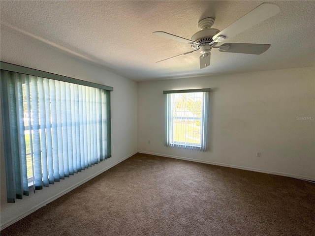 carpeted spare room with a ceiling fan and a textured ceiling