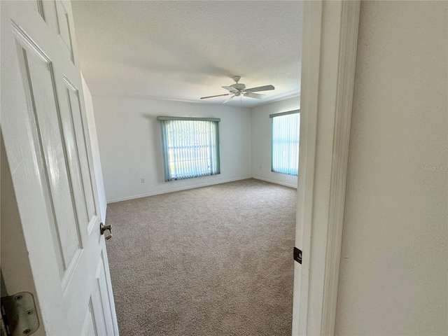 carpeted empty room featuring ceiling fan and a textured ceiling