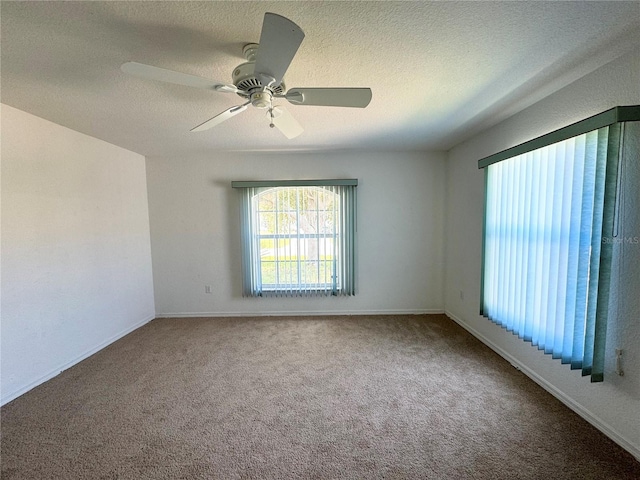 carpeted empty room with a ceiling fan and a textured ceiling