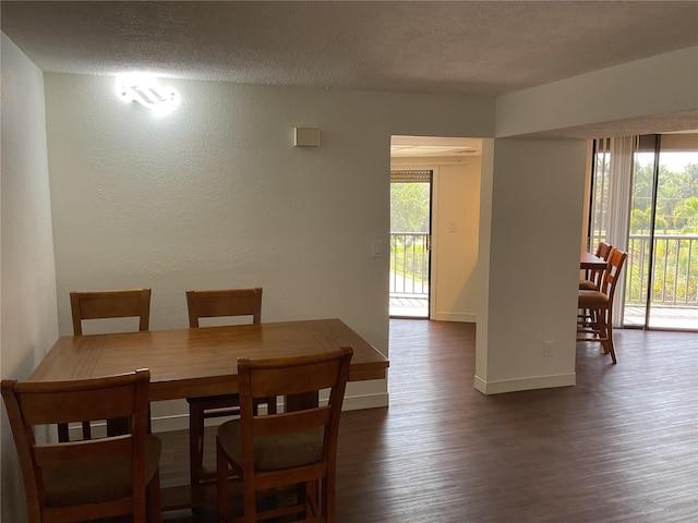 dining space featuring a textured ceiling and dark hardwood / wood-style flooring