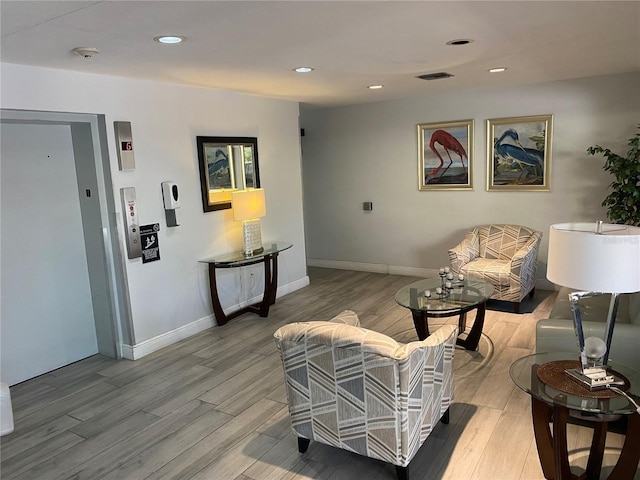 living room with light hardwood / wood-style floors and elevator