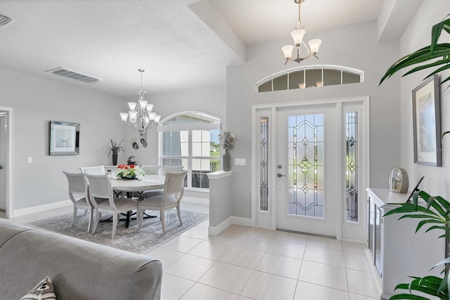 tiled foyer with a notable chandelier and a textured ceiling