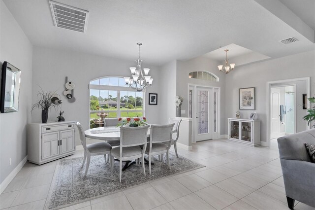 tiled dining room with an inviting chandelier