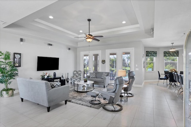 living area with french doors, a tray ceiling, visible vents, and baseboards