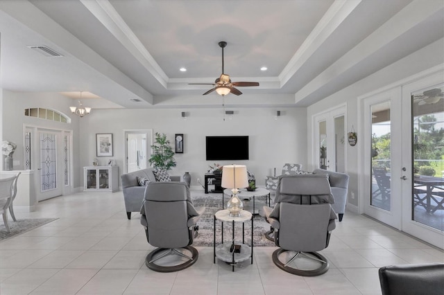 living area with a tray ceiling, french doors, light tile patterned floors, visible vents, and plenty of natural light