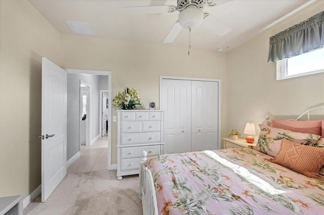 bedroom featuring ceiling fan, a closet, baseboards, and light colored carpet