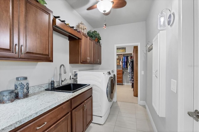 laundry room featuring cabinet space, ceiling fan, washing machine and clothes dryer, a sink, and light tile patterned flooring