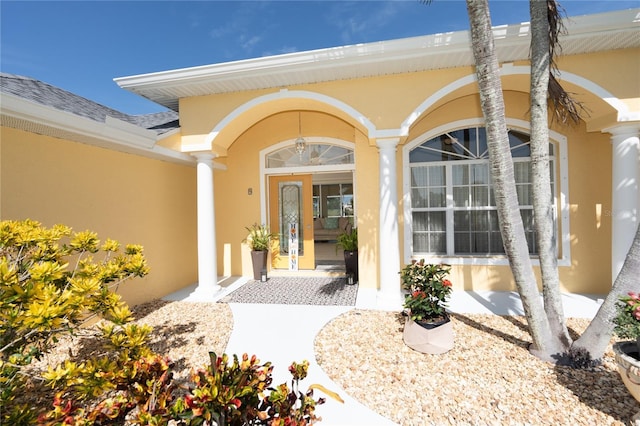 doorway to property with roof with shingles and stucco siding