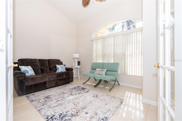 living room with high vaulted ceiling and light tile patterned flooring