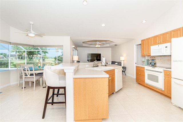 kitchen with ceiling fan, a center island with sink, white appliances, and light tile patterned floors