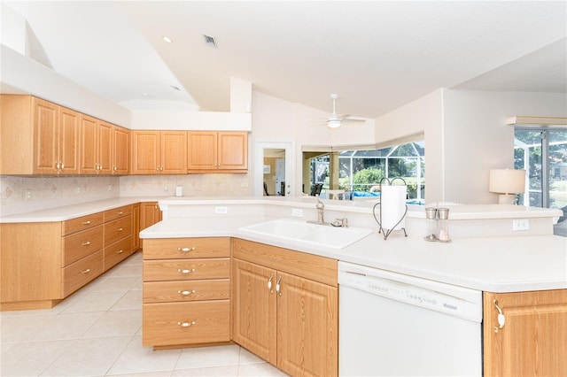 kitchen with light tile patterned floors, a kitchen island, white dishwasher, light countertops, and a sink