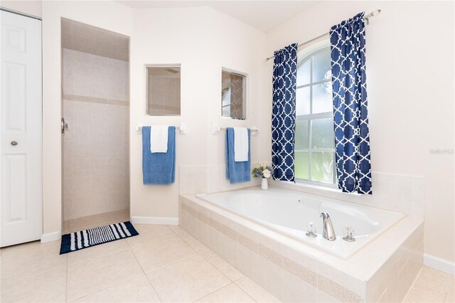 bathroom featuring tiled tub and tile patterned floors