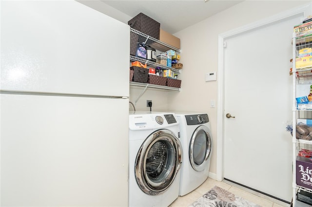 laundry area with light tile patterned floors and washer and dryer