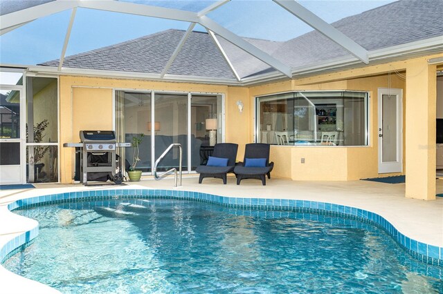 view of swimming pool with area for grilling, a patio, and a lanai