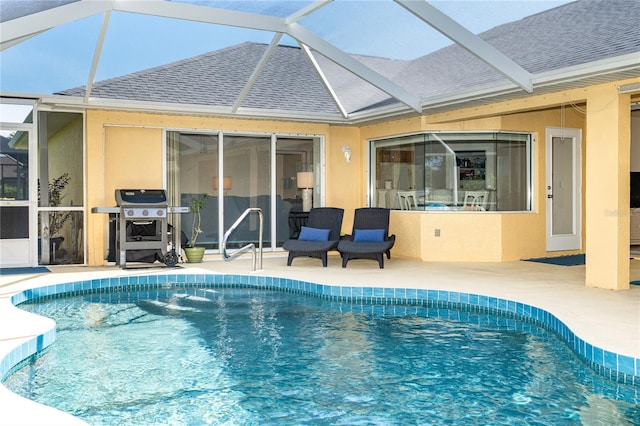 pool with glass enclosure, a patio area, and a grill