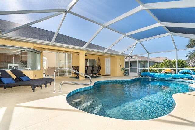 view of swimming pool with glass enclosure and a patio area