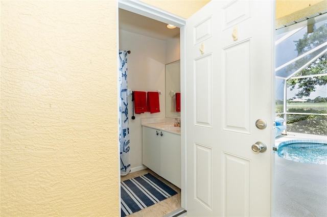 bathroom featuring a sink and a textured wall