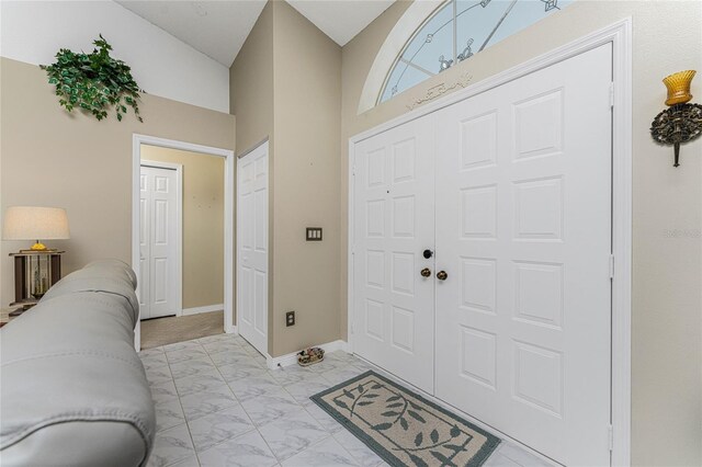 tiled entryway with vaulted ceiling