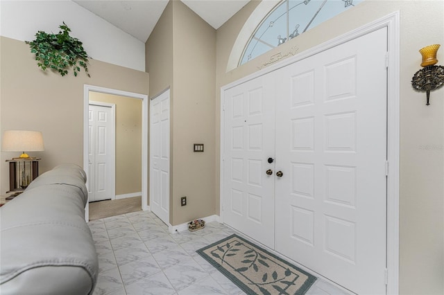 foyer entrance with marble finish floor and baseboards