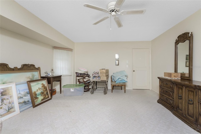 living area featuring light carpet and a ceiling fan