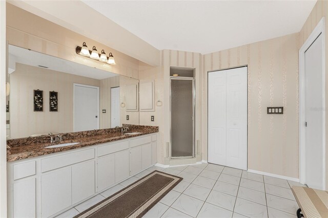 bathroom featuring a shower with door, vanity, and tile patterned floors