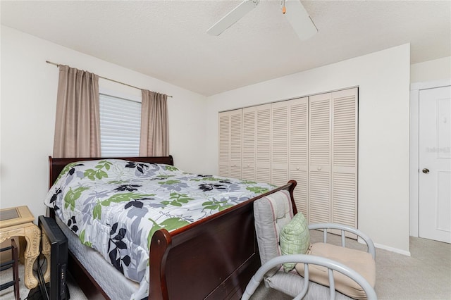 carpeted bedroom featuring baseboards, a textured ceiling, a ceiling fan, and a closet