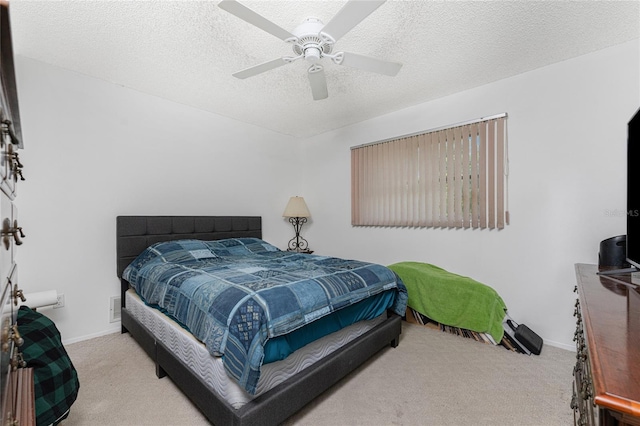 bedroom with ceiling fan, light carpet, and a textured ceiling