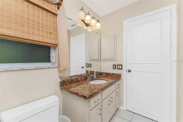 bathroom with tile patterned flooring, toilet, and vanity