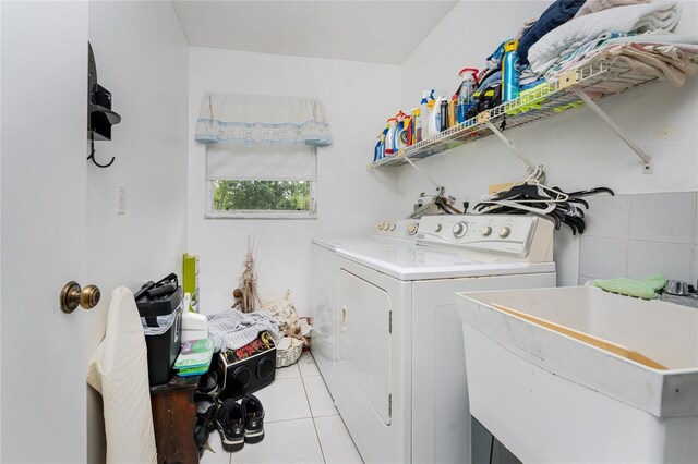 washroom featuring separate washer and dryer, sink, and light tile patterned flooring