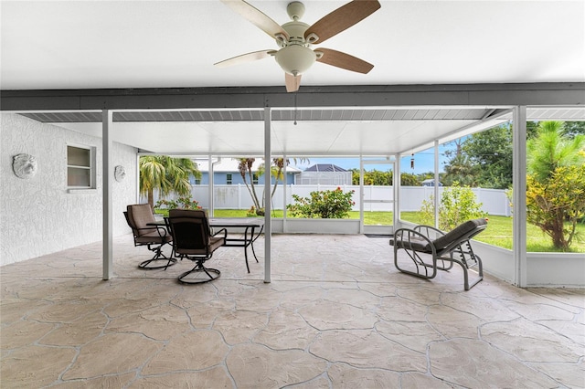 sunroom / solarium with ceiling fan and beamed ceiling