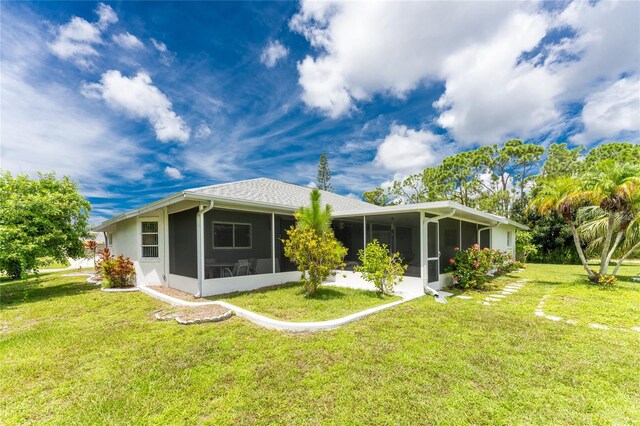 back of house featuring a sunroom and a yard