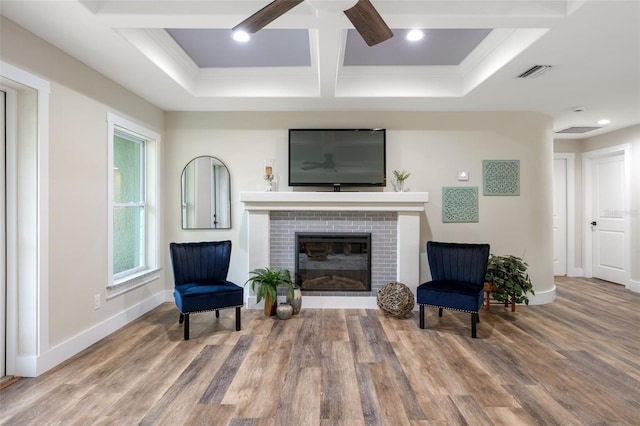 living area with hardwood / wood-style flooring, ceiling fan, and a fireplace