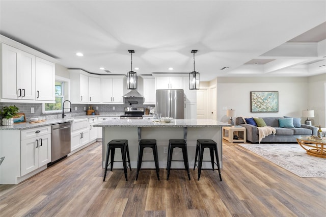 kitchen featuring white cabinets, appliances with stainless steel finishes, a center island, and dark hardwood / wood-style flooring