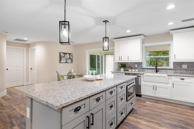 kitchen with backsplash, dark hardwood / wood-style floors, white cabinetry, and sink