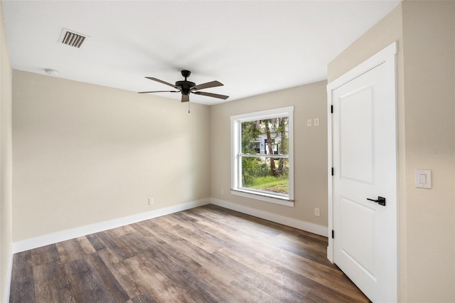 unfurnished room with ceiling fan and dark hardwood / wood-style flooring