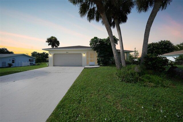 single story home with a garage and a yard