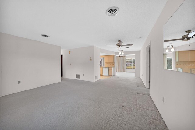 unfurnished living room with light carpet, visible vents, and a ceiling fan