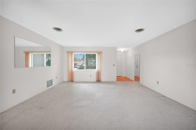 spare room with visible vents and light colored carpet