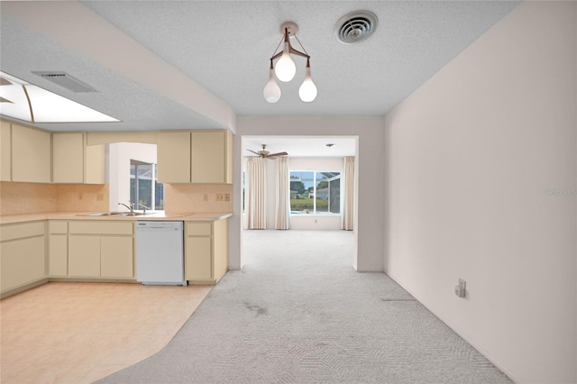 kitchen with white dishwasher, visible vents, light countertops, and cream cabinetry