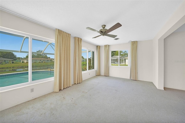 unfurnished room with light carpet, a textured ceiling, and a ceiling fan