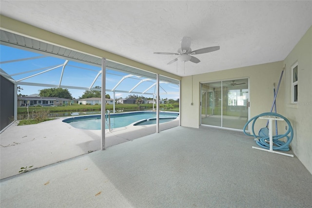 outdoor pool with ceiling fan, a patio, and glass enclosure