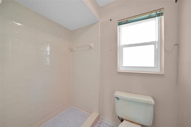 bathroom featuring a textured ceiling, a shower stall, toilet, and baseboards