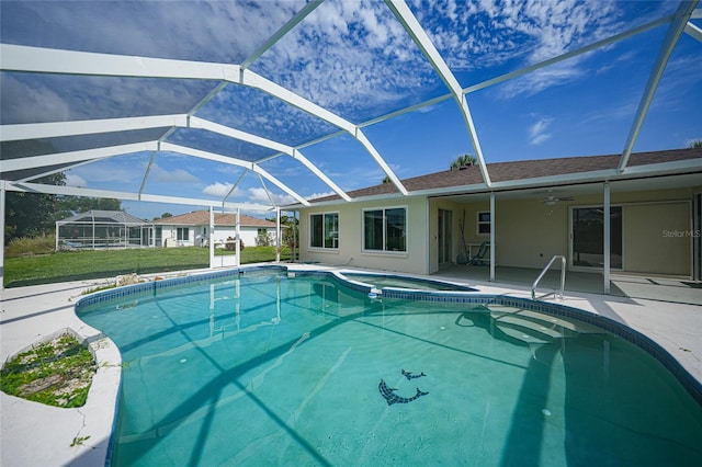 outdoor pool with ceiling fan, glass enclosure, and a patio area