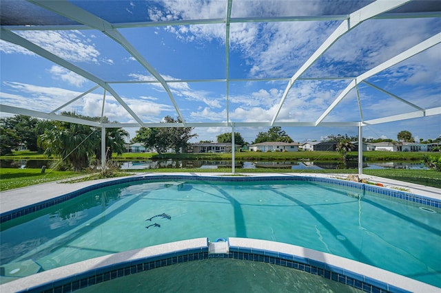 view of swimming pool featuring glass enclosure, a water view, and a pool with connected hot tub