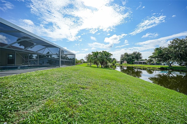 view of yard with glass enclosure and a water view