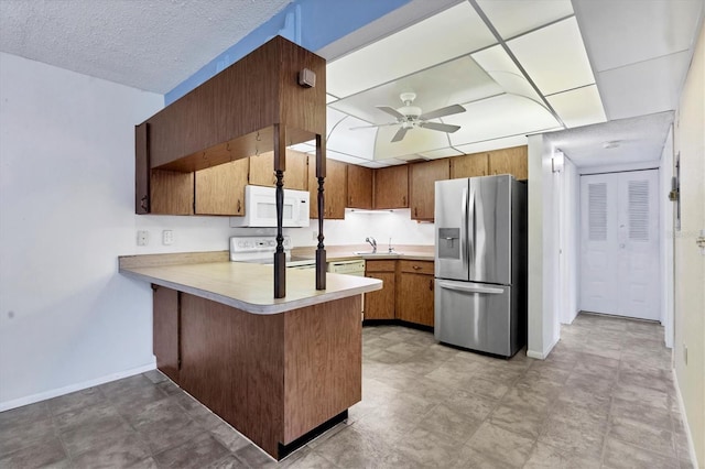 kitchen with kitchen peninsula, white appliances, ceiling fan, and sink