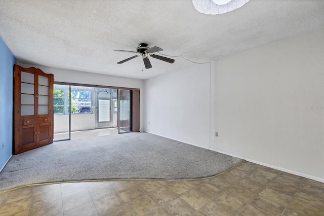 empty room featuring a textured ceiling, carpet, and ceiling fan