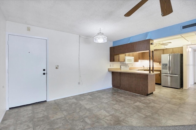 kitchen featuring ceiling fan, sink, kitchen peninsula, white appliances, and a textured ceiling