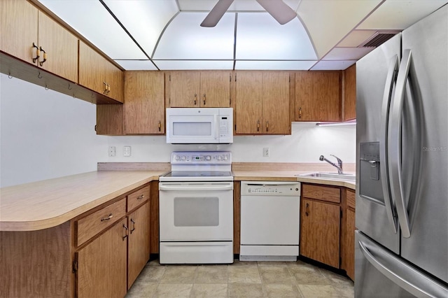 kitchen with white appliances, kitchen peninsula, a drop ceiling, ceiling fan, and sink