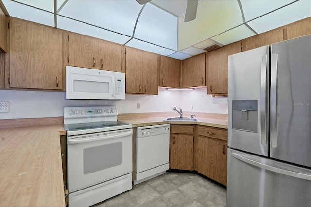 kitchen with white appliances, sink, and ceiling fan